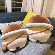 Pilz kuscheltier als niedlicher Plueschpilz auf dem Sofa, Rueckenansicht mit Schultertasche