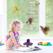 Schmetterling spielzeug fuer Babys, Kleinkind spielt mit fliegenden Schmetterlingen im Wohnzimmer