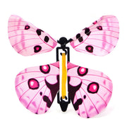 Schmetterling spielzeug in Rosa, Frontansicht eines fliegenden Schmetterlings mit Gummimechanismus